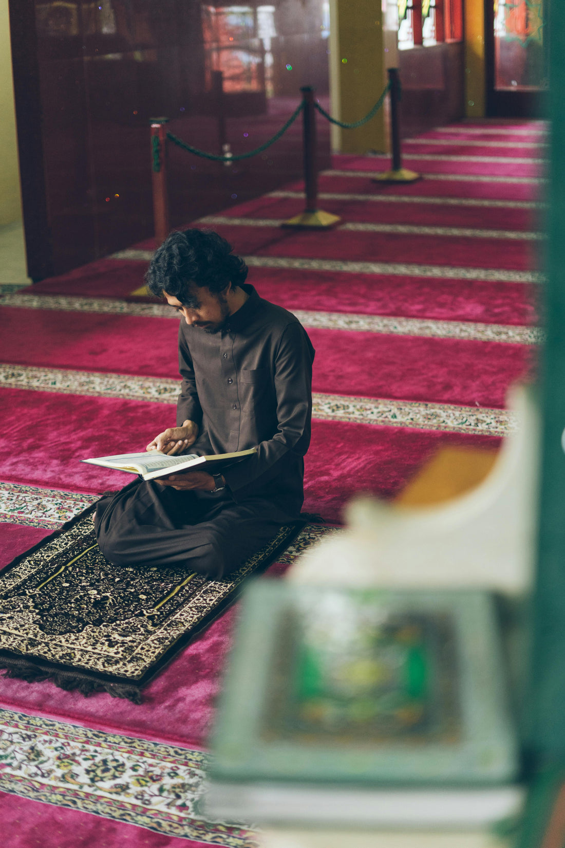 Personne en prière sur tapis dans une mosquée pendant la salat